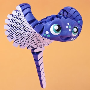 May include: An articulated stingray figure constructed from purple and light purple plastic segments. The creature features large eyes with white and teal accents, a textured wing pattern, and a long segmented tail, showcasing a flexible design.