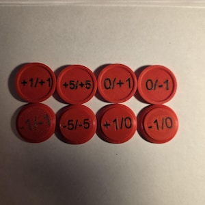 May include: Eight circular red plastic tokens arranged in two rows of four. Each token features black printed text displaying various numerical values including +1/+1, +5/+5, 0/+1, 0/-1, -1/-1, -5/-5, +1/0, and -1/0, with a raised border edge.