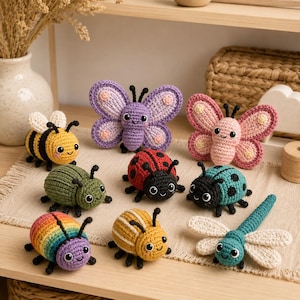 Pode incluir: Uma coleção de oito pequenas figuras de insetos e borboletas feitas em crochê. O conjunto inclui uma abelha amarela e preta, uma borboleta roxa, uma borboleta rosa, um besouro verde, uma joaninha vermelha, uma joaninha turquesa e uma libélula.