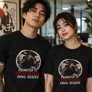 Peut inclure: Deux t-shirts noirs à manches courtes avec un motif circulaire représentant un personnage de style anime assis à un bureau avec des écrans d'ordinateur. Sous le motif, le texte indique : PROMOTED TO PROFESSIONAL EMAIL READER en lettres blanches et rouges.