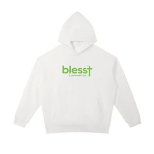 May include: A white long-sleeve hooded sweatshirt featuring a front kangaroo pocket. The chest displays the green text "blesst" with a cross integrated into the letter "t," followed by the smaller dark green text "CLOTHING CO." below it.