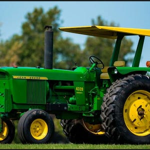 Peut inclure: Un tracteur diesel John Deere 4320 vert doté d'un auvent jaune, d'un tuyau d'échappement vertical noir et de grands pneus noirs avec des jantes jaunes. Le tracteur possède un volant, un siège et le numéro de modèle sur le panneau latéral.