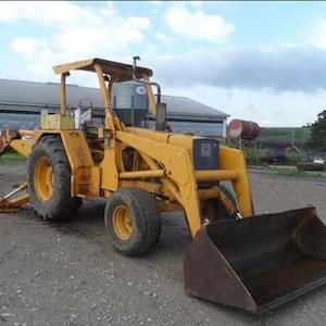 Peut inclure: Une tractopelle industrielle jaune équipée d'un godet frontal et d'un bras d'excavation arrière. Ce véhicule de chantier robuste possède de grands pneus noirs, un poste de conduite ouvert avec un toit de protection et un tuyau d'échappement.