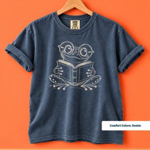 Reading shirt with a whimsical sketch style frog wearing big round glasses while reading a book, cute frog shirt, book club sweatshirt, book lover shirt, frog reading shirt, bookish shirt, book club shirt, library shirt, book lover gift, frog lover gift, frog sweatshirt, bookish sweatshirt, comfort colors shirt, reader shirt, bookworm gift, reading lover gift, librarian shirt, cute frog gift, bookish gift, book club tee
