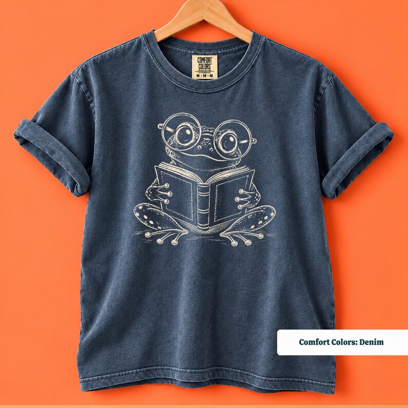 Reading shirt with a whimsical sketch style frog wearing big round glasses while reading a book, cute frog shirt, book club sweatshirt, book lover shirt, frog reading shirt, bookish shirt, book club shirt, library shirt, book lover gift, frog lover gift, frog sweatshirt, bookish sweatshirt, comfort colors shirt, reader shirt, bookworm gift, reading lover gift, librarian shirt, cute frog gift, bookish gift, book club tee