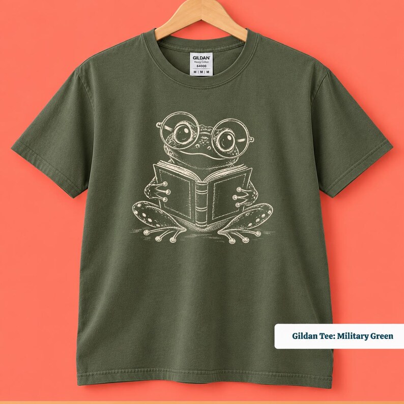 Cute frog shirt showing a quirky hand drawn frog wearing big nerdy round glasses while reading a book, book club sweatshirt, book lover shirt, reading shirt, frog reading shirt, bookish shirt, book club shirt, library shirt, book lover gift, frog lover gift, frog sweatshirt, bookish sweatshirt, comfort colors shirt, cute bookworm shirt, reader gift, librarian gift, book club gift, reading lover gift, frog reader shirt