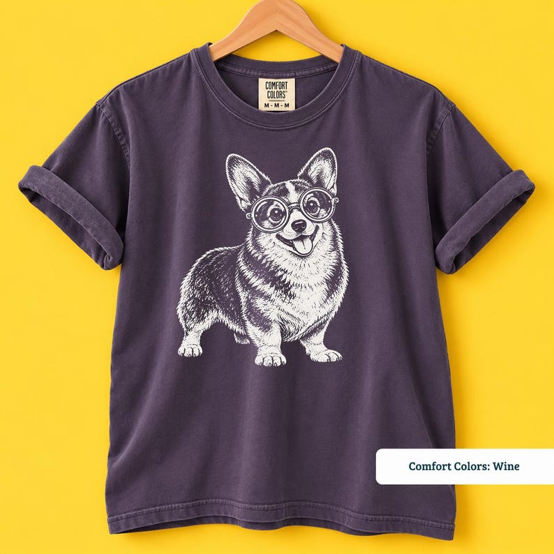 This corgi shirt and corgi merchandise mockup shows a charming corgi with glasses in a fun retro inspired design. A great example of a geeky corgi shirt, corgi nerd shirt, and vintage corgi shirt that also makes a playful nerdy dog shirt for corgi lovers.