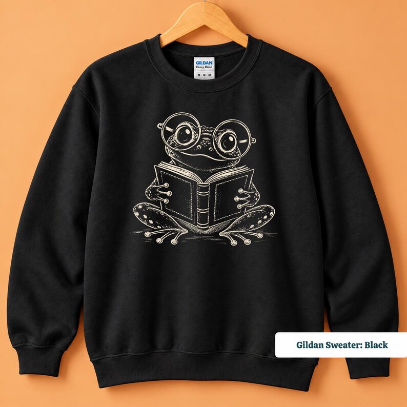 Bookish sweatshirt featuring a cute hand sketched frog wearing big round glasses and enjoying a book, cute frog shirt, book club sweatshirt, book lover shirt, reading shirt, frog reading shirt, bookish shirt, book club shirt, library shirt, book lover gift, frog lover gift, frog sweatshirt, comfort colors shirt, bookworm gift, reader shirt, reading lover gift, librarian gift, book club gift, cute frog tee, bookish gift