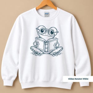 Frog sweatshirt featuring a whimsical sketch style frog with large nerdy glasses reading an open book, cute frog shirt, book club sweatshirt, book lover shirt, reading shirt, frog reading shirt, bookish shirt, book club shirt, library shirt, book lover gift, frog lover gift, bookish sweatshirt, comfort colors shirt, bookworm shirt, reader gift, book club gift, librarian gift, reading lover gift, cute frog gift, bookish frog shirt