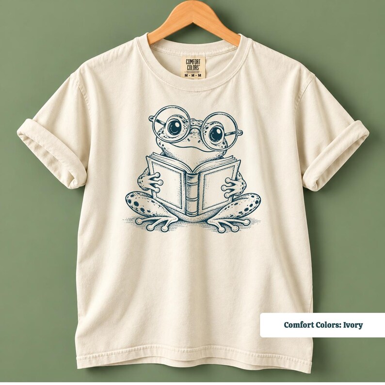 Book club shirt featuring a cute hand drawn frog with big circular glasses reading a book, cute frog shirt, book club sweatshirt, book lover shirt, reading shirt, frog reading shirt, bookish shirt, library shirt, book lover gift, frog lover gift, frog sweatshirt, bookish sweatshirt, comfort colors shirt, book club gift, reader gift, bookworm shirt, reading lover shirt, librarian gift, cute bookish shirt, frog reader gift