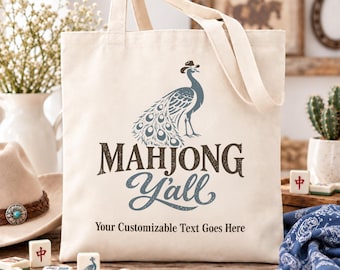 May include: A cream-colored canvas tote bag featuring a graphic of a peacock wearing a cowboy hat. Below the peacock, the text reads "MAHJONG Y'ALL" in dark brown and blue, followed by the line "Your Customizable Text Goes Here" in black.