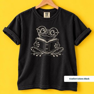 Bookish shirt with a cute sketch frog wearing oversized glasses and quietly reading an open book, cute frog shirt, book club sweatshirt, book lover shirt, reading shirt, frog reading shirt, book club shirt, library shirt, book lover gift, frog lover gift, frog sweatshirt, bookish sweatshirt, comfort colors shirt, bookworm gift, reader shirt, bookish gift, reading lover gift, librarian shirt, cute frog gift, book club gift