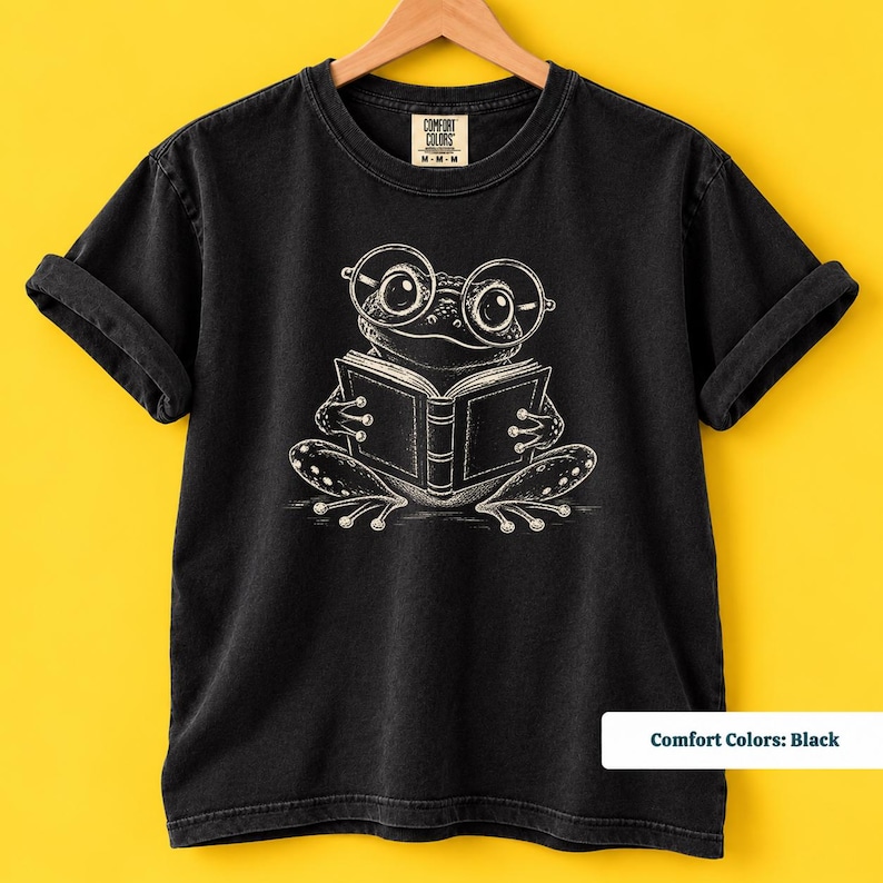 Bookish shirt with a cute sketch frog wearing oversized glasses and quietly reading an open book, cute frog shirt, book club sweatshirt, book lover shirt, reading shirt, frog reading shirt, book club shirt, library shirt, book lover gift, frog lover gift, frog sweatshirt, bookish sweatshirt, comfort colors shirt, bookworm gift, reader shirt, bookish gift, reading lover gift, librarian shirt, cute frog gift, book club gift