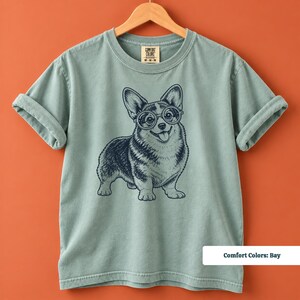 This corgi shirt and corgi merchandise design shows a lovable corgi with glasses in a fun vintage inspired illustration. The retro corgi shirt aesthetic is ideal for anyone looking for a geeky corgi shirt, nerdy dog shirt, corgi mom shirt, or unique vintage dog tee.