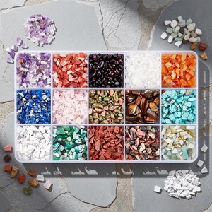 May include: A rectangular white plastic organizer tray containing fifteen separate compartments filled with assorted small, polished gemstone chips in various colors including purple, red, black, white, orange, blue, pink, green, brown, and turquoise.