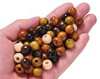 May include: A collection of small, round wooden beads in various shades of brown, tan, black, and cream. Each bead features a central hole for threading. The beads have a smooth, polished finish and are presented in a loose, mixed assortment.