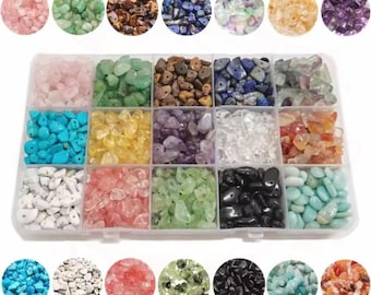 May include: A rectangular clear plastic storage container with fifteen compartments, each filled with different colored and textured gemstone chips. The collection includes rose quartz, green aventurine, tiger eye, lapis lazuli, amethyst, and clear quartz.