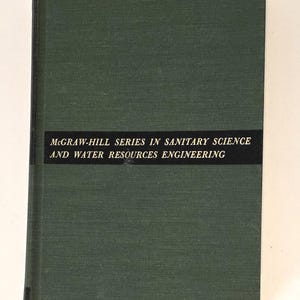 May include: A dark green hardcover book with a black horizontal band across the front cover. The text on the band reads: MCGRAW-HILL SERIES IN SANITARY SCIENCE AND WATER RESOURCES ENGINEERING. The book has a textured, fabric-like cover material.