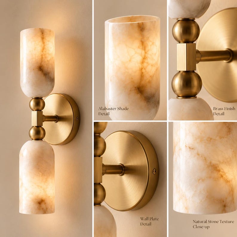 May include: A wall sconce featuring two cylindrical alabaster shades with natural veining and a brushed brass finish. The fixture includes a circular wall plate, a central brass stem with spherical accents, and illuminated stone shades.