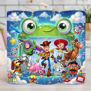 May include: A cylindrical tumbler featuring a vibrant blue sky background with white clouds and stars. The design displays a large green frog face at the top and various animated characters including a cowboy, space ranger, cowgirl, and horse.