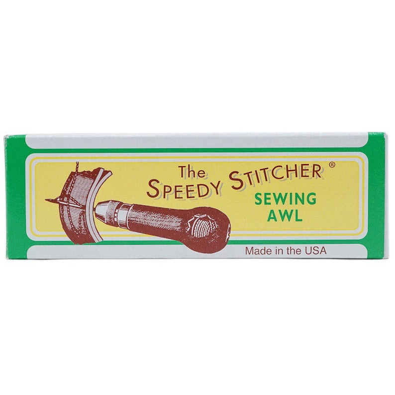 K&ouml;nnte beinhalten: Eine gr&uuml;n-wei&szlig;e Schachtel mit der Aufschrift "The Speedy Stitcher Sewing Awl". Die Schachtel zeigt eine braune Illustration des Ahlenwerkzeugs. Der Text "Made in the USA" ist ebenfalls sichtbar.