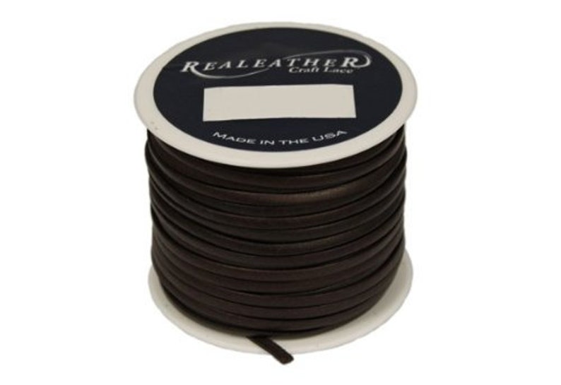 Op de afbeelding: Een spoel met bruin lederen koord, met het label "Realeather Craft Leather" en "Made in the USA".