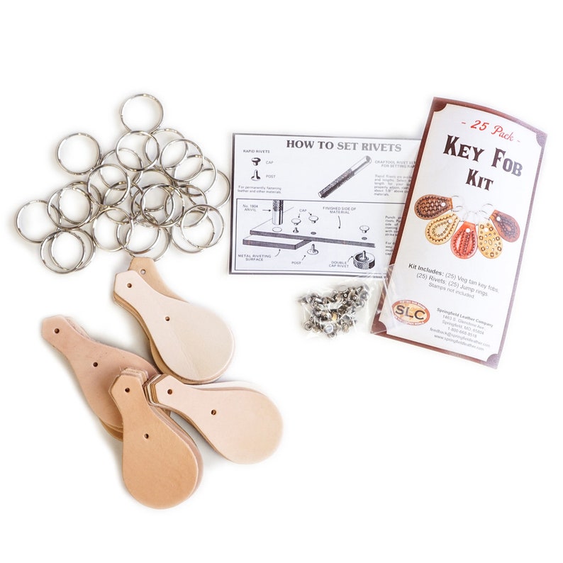 May include: A leather key fob kit with 25 tan leather key fob blanks, 25 silver jump rings, 25 silver rivets, and instructions on how to set rivets. The kit is packaged in a brown paper bag with a white label that says "SLC Springfield Leather Company".