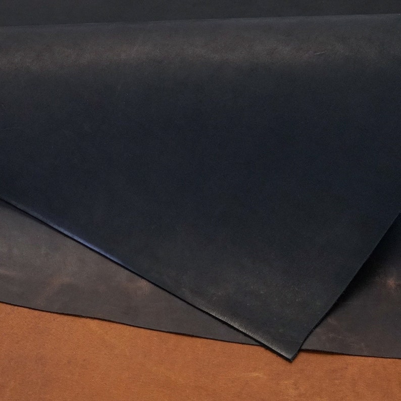 Puede incluir: Tres piezas de cuero en diferentes tonos de marr&oacute;n, negro y beige. El cuero est&aacute; doblado y apilado uno encima del otro.
