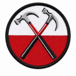 May include: A circular embroidered patch featuring a background split horizontally into white and red sections. Two grey hammers with red and black handles are crossed in the center. The entire design is bordered by a thick black stitched edge.
