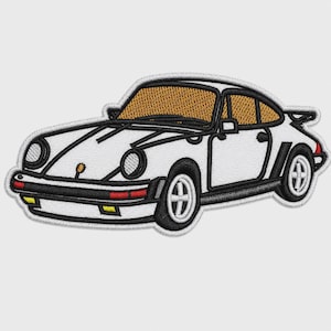 May include: An embroidered patch featuring a white sports car with a tan interior, black trim, and black wheels. The design includes circular headlights, a front bumper with yellow and red accents, and a rear spoiler, all outlined in white thread.