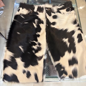 Pantalones cortos de hombre de piel de vaca con pelo, en combinación de blanco y negro.