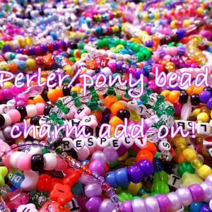 May include: A large collection of colorful plastic pony beads and Perler beads strung together into multiple bracelets. The beads feature various shapes, including stars and flowers, with some white letter beads spelling out words like RESPECT.