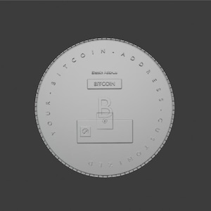 May include: A circular silver-toned coin featuring the text YOUR BITCOIN ADDRESS CUSTOMIZED embossed along the rim. The center displays the word BITCOIN, a large letter B, and a rectangular space with a small square icon and a dot inside.