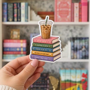 May include: A die-cut sticker featuring a stack of five colorful books topped with an iced coffee in a clear plastic cup. The book spines are labeled with the text: GOOD IDEAS, CHAPTERS & COFFEE, DREAM. PLAN. DO., BE KIND TO YOUR MIND, and STORIES THAT STAY.