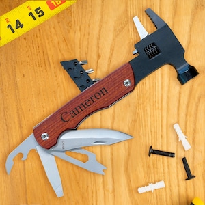 May include: A multi-tool hammer with a wooden handle and a personalized inscription that reads "Cameron". The tool has a hammer head, a wrench, a screwdriver, a knife, and a file.