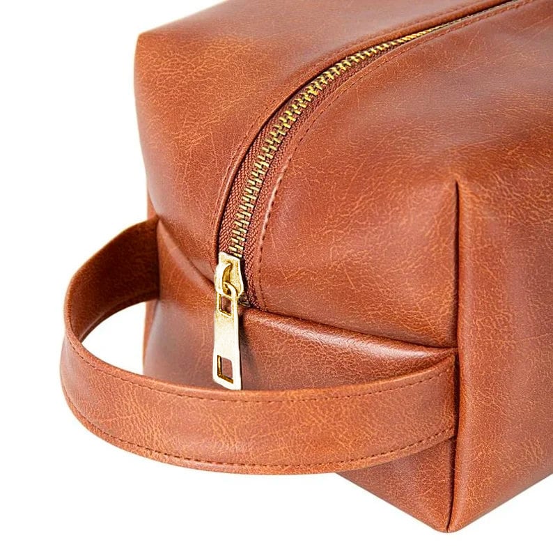 May include: A brown leather travel bag with a gold zipper and a brown leather handle.