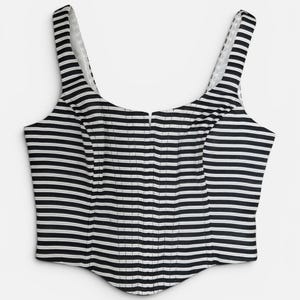 May include: A sleeveless corset-style top featuring a black and white horizontal striped pattern. The garment has a scoop neckline, wide shoulder straps, and a curved, pointed hemline at the bottom with vertical stitched detailing along the front.