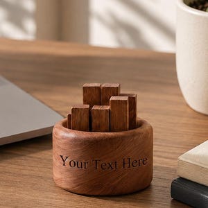 May include: A round, brown wooden container holding several small, upright rectangular wooden blocks. The exterior of the container features the engraved text "Your Text Here" in a dark, sans-serif font, centered on the smooth, curved surface.