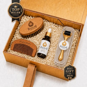 Könnte beinhalten: Eine goldene Geschenkbox mit einer ovalen Bartbürste aus Holz, einem Bartkamm aus Holz, einer 30-ml-Flasche Barakah Blends Bartöl mit Pipette und einem goldfarbenen Derma-Roller in einem durchsichtigen Kunststoffetui.