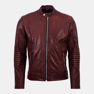 May include: A dark burgundy leather jacket featuring a stand-up collar with a snap button closure, a central silver-toned zipper, ribbed padding on the shoulders and elbows, and two zippered side pockets on the front of the garment.