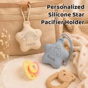 May include: Two star-shaped silicone pacifier holders with loops, one beige with a rainbow and the name Carrie, one blue with a cloud and the name Randy. A yellow pacifier and a wooden bear-shaped teether are included. Text reads Personalized Silicone Star Pacifier Holder.