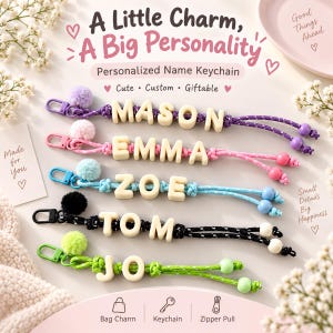 Può includere: Cinque portachiavi personalizzati con perline a forma di lettera color crema su cordini colorati, completati da pompon e clip abbinati. Sono visibili i nomi MASON, EMMA, ZOE, TOM e JO. Il testo include A Little Charm, A Big Personality, Bag Charm, Keychain, Zipper Pull.