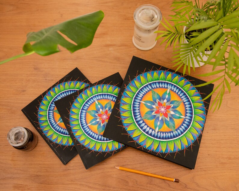 May include: Three black notebooks with colorful mandala designs on the covers. The mandalas feature blue, green, yellow, orange, and red colors.