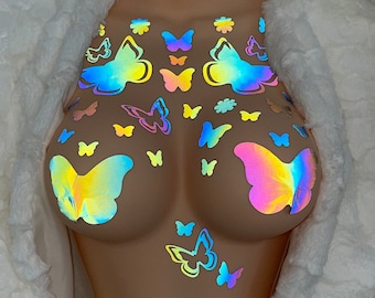 Könnte beinhalten: Ein Set mit regenbogenfarbenen, holografischen Schmetterlingsaufklebern. Die Aufkleber sind in einem Muster auf einem nackten Hintergrund angeordnet.