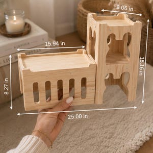 May include: A light-colored wooden modular structure consisting of a low rectangular platform with vertical slats and a taller two-tiered tower section. The overall dimensions are 25.00 inches long, 9.06 inches wide, and 15.16 inches high, with the base measuring 8.27 inches high.