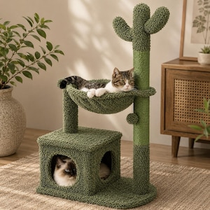 Puede incluir: Un árbol para gatos verde con un poste superior en forma de cactus, una hamaca circular y una base cuadrada. La estructura está cubierta de tela texturizada y cuerda de sisal, ofreciendo múltiples niveles para descansar y jugar.