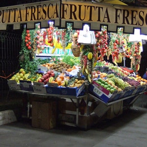 May include: A fruit stand with a sign that reads 
