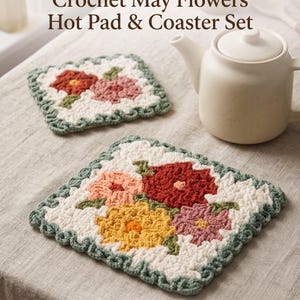 Può includere: Due presine e sottobicchieri quadrati all'uncinetto con motivi floreali rossi, gialli, rosa e verdi su sfondo crema con un bordo smerlato verde salvia. Il testo recita: Crochet May Flowers Hot Pad & Coaster Set. Instant PDF Download.