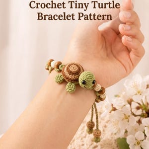 Puede incluir: Una pulsera de ganchillo con una pequeña tortuga de caparazón marrón y cuerpo verde claro, decorada con cuentas de madera marrones y blancas. El texto dice Crochet Tiny Turtle Bracelet Pattern e Instant PDF Download.