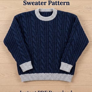 Puede incluir: Un suéter de manga larga azul marino con un patrón de tejido de cable vertical, cuello redondo gris claro, puños gris claro y dobladillo gris claro. El texto Cable Up Crochet Sweater Pattern e Instant PDF Download es visible.